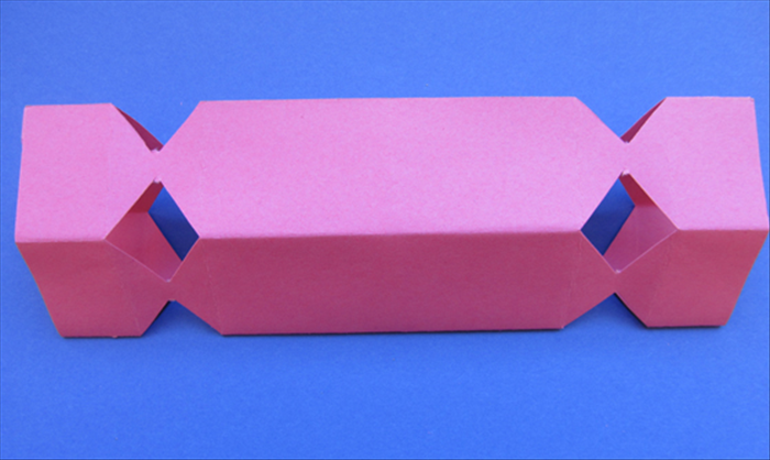 Stick your fingers inside and push outwards to make the box shape