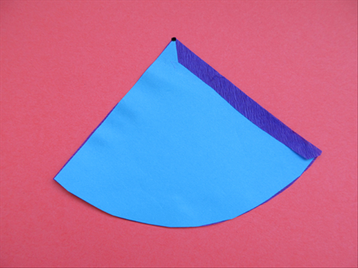Fold the edge over and glue in place.

Cut a very tiny piece off the top point. Very tiny!

Your cone shape is ready to be decorated and rolled up.
