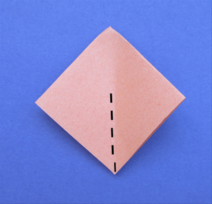 Flip the paper over to the back side.  The open end should be at the bottom.
Bring the side points together and pinch a fold only half of the way down.
