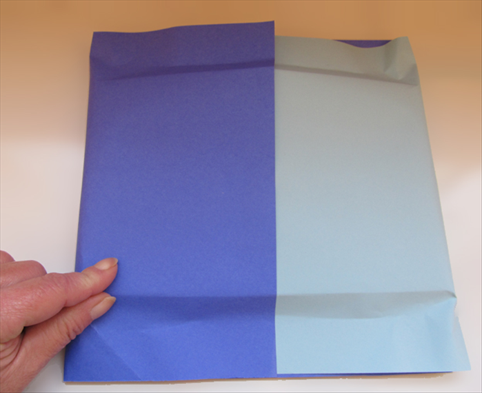 Flip the present over to the back side.
Pinch the paper along the top and bottom edges of the present.
