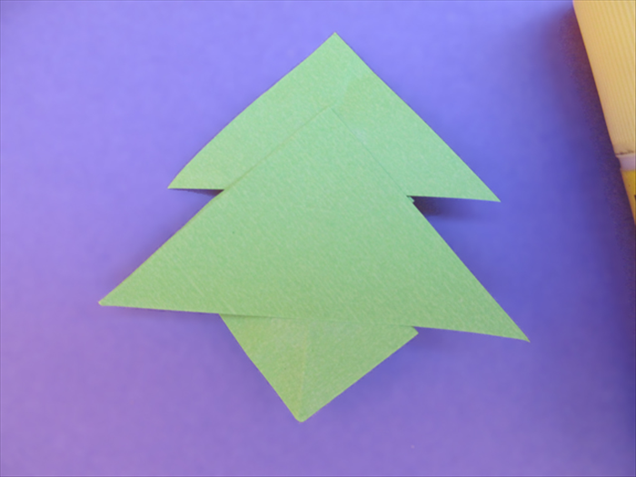 Flip the triangles over to the back side.
Glue the top of the largest triangle to the pinch mark of the second largest triangle.
