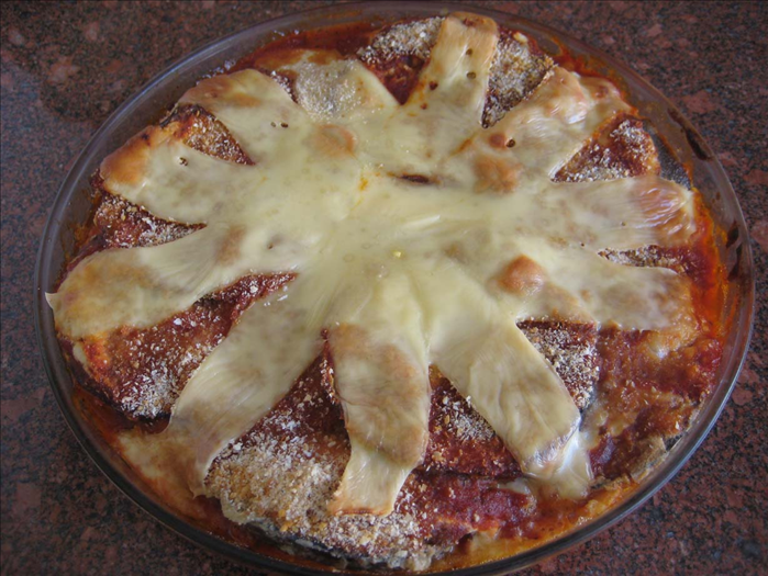 Ingredients:
1 very large eggplant
1 medium onion chopped
2 cloves garlic crushed
1 medium can of tomato paste
½ cup water
1 teaspoon sugar
½ teaspoon salt
½ teaspoon dried basel leaves
½ teaspoon dried oregano leaves
¼ teaspoon black pepper
1 container of cottage cheese
Mozzarella or yellow cheese 
Flour
breadcrumbs
1 – 2 eggs
Oil for frying
