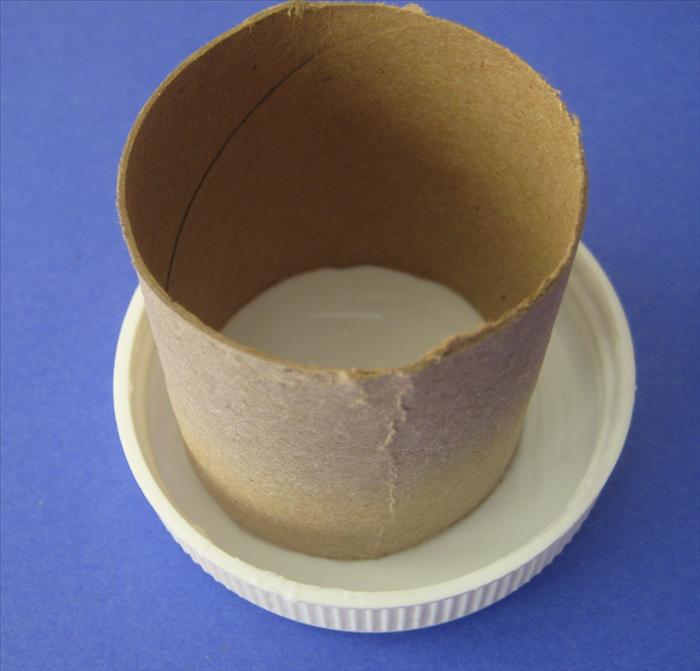 Pour plastic glue into a cover or other object  that you do not need.
Place the toilet paper roll into it.
Turn it around to make sure that all of the edge is covered generously with glue
