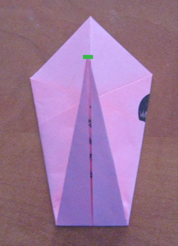 Fold the bottom point up  towards the top , halfway up the top triangle.