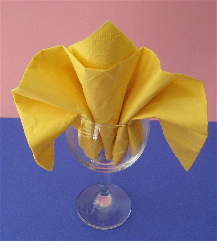 Pull down the sides and your Fleur de lys napkin fold is finished. 