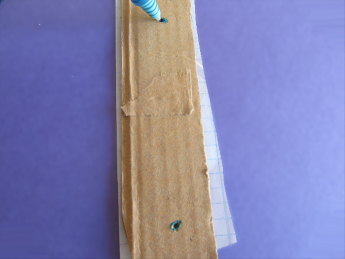 <p> Place a strip of paper beneath the cardboard strip.</p> 
<p> Insert your pen tip in the holes to make 2 marks.</p> 
<p>  </p>