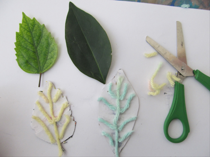 Glue more pieces of wool or chord where you see veins on the real leaves.
When the glue has dried completely cut off the extra sticking out of the edges.
