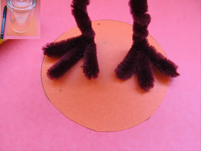 Trace a circle and cut it out.
Spread a generous amount of glue to the bottoms of the feet.
Press them down onto the circle and hold them in place until the glue has dried.
