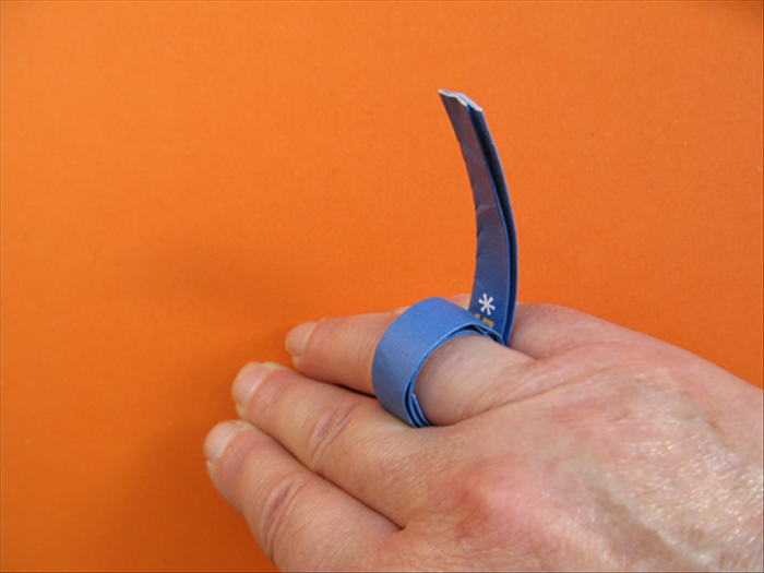 Take a strip and wrap it around you knuckle. Put glue on the strip to hold it in place.