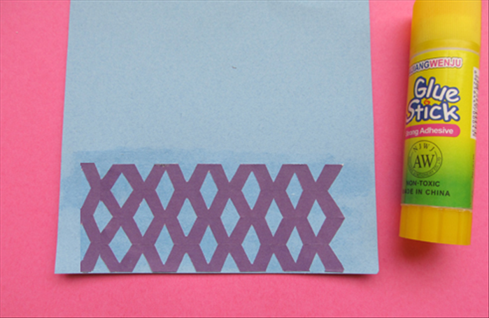 Carefully unfold the paper you just cut.

Apply glue to the paper you want for the background.  The back ground paper should be a little longer than the cut strip. See the picture.

Place the cut paper on top and smooth it out. 
